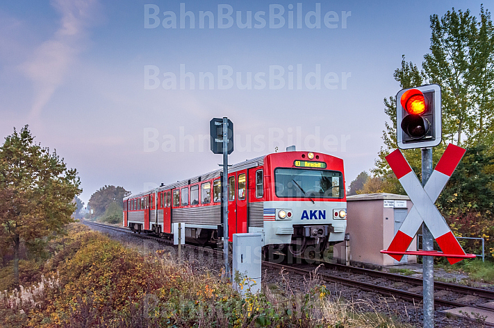 Ein Triebwagen der AKN im herbstlichen Frühnebel an einem Bahnübergang bei Sparrieshoop in Schleswig-Holstein